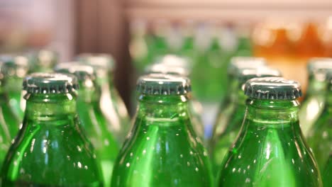 primer plano de botellas verdes en una vitrina