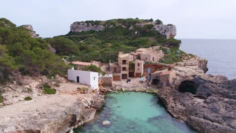 flying towards s'almonia small fisherman houses at mallorca island, aerial