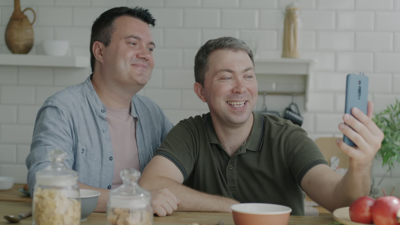 Two men having breakfast and video call