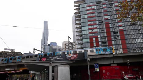 tram travels under urban skyline and buildings