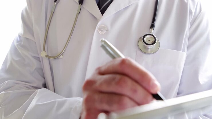 Doktor, der auf Klemmbrett schreibt