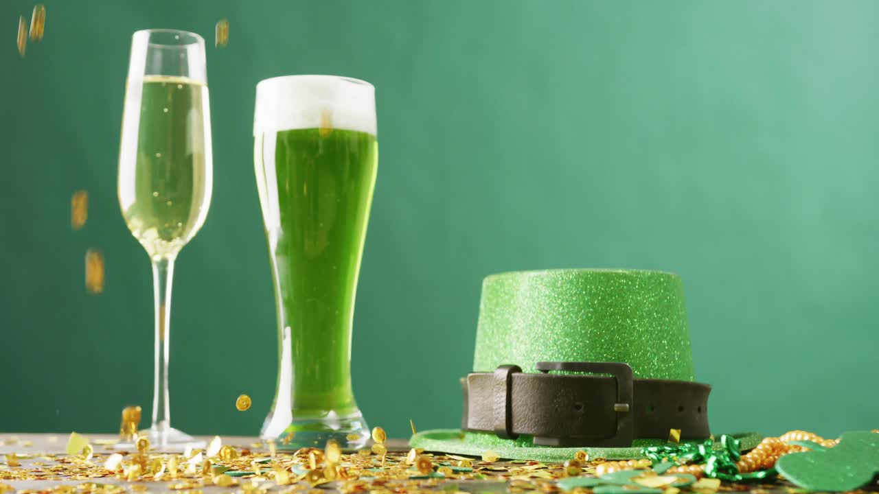 Video of st patrick's glass of champagne, beer, hat with copy space on green background