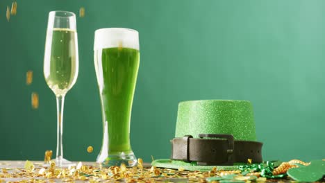 Video-of-st-patrick's-glass-of-champagne,-beer,-hat-with-copy-space-on-green-background