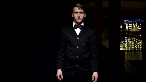 successful young businessman standing in a hall at night