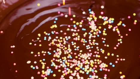 sprinkles scatter over a smooth chocolate surface