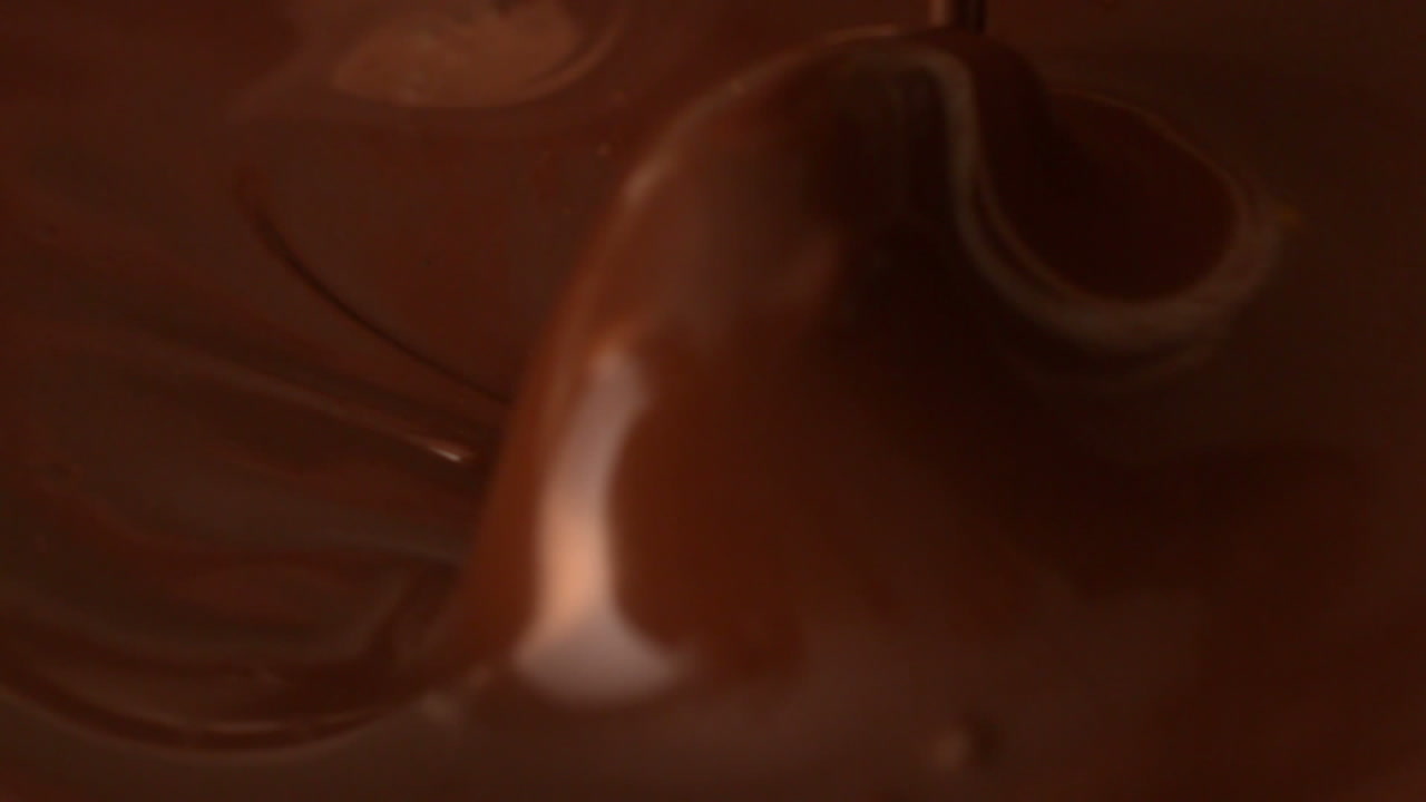 Spoon moving in melted chocolate