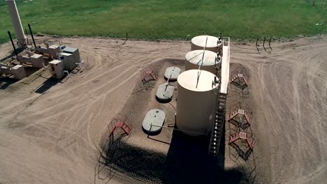 fracking pad with three large petroleum tanks