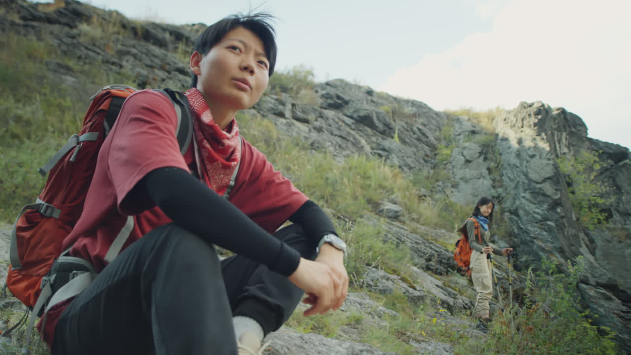 Asian Female Tourists Taking Break while Hiking