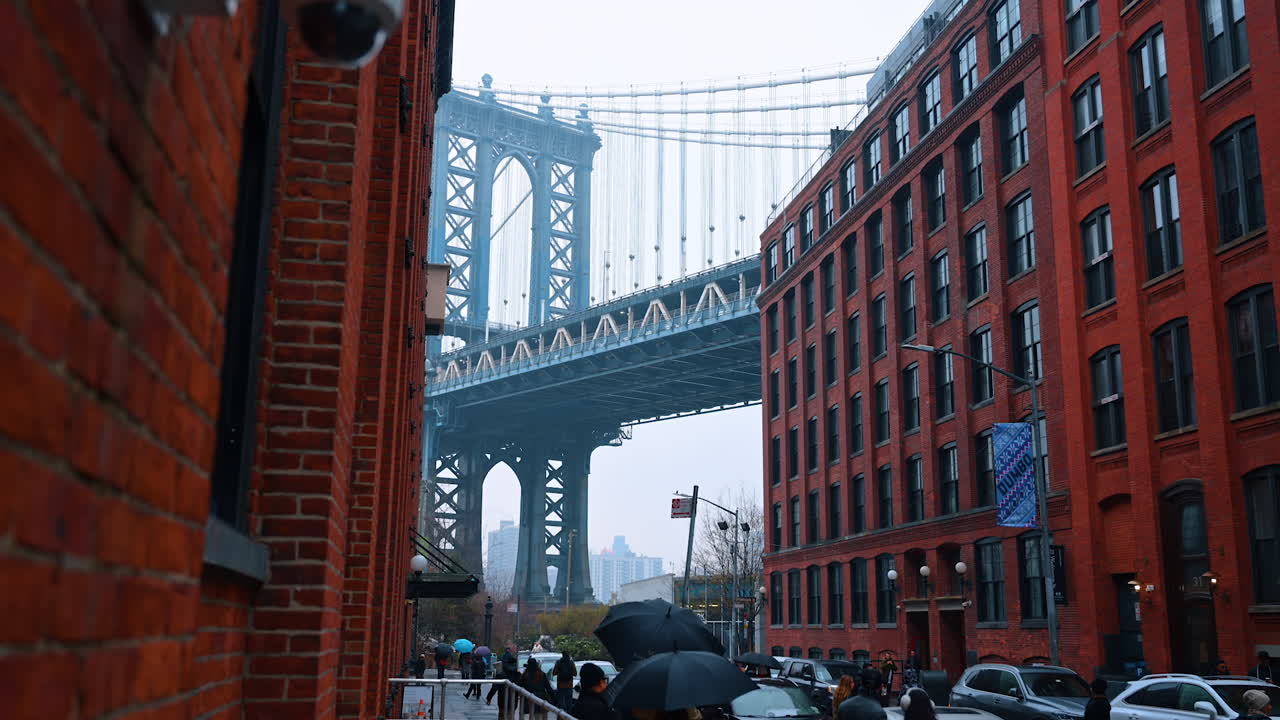 Vista da Manhattan Bridge a partir de DUMBO, Brooklyn. Perspectiva clássica da Manhattan Bridge vista entre edifícios históricos de tijolos vermelhos em DUMBO.