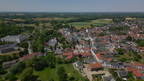drone de gran ángulo filmado sobre la comuna histórica de maasgouw, espina en limburgo con una hermosa vista de la iglesia de las abadías de limburgo, casas y el paisaje plano en un día soleado