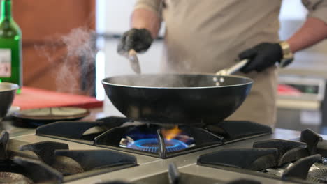 chef cooking in a wok on a gas stove