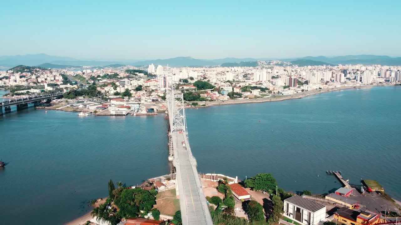 A panoramic drone view capturing the majestic beauty of the Herc&iacute;lio Luz Bridge in Florian&oacute;polis, an iconic landmark against the coastal backdrop