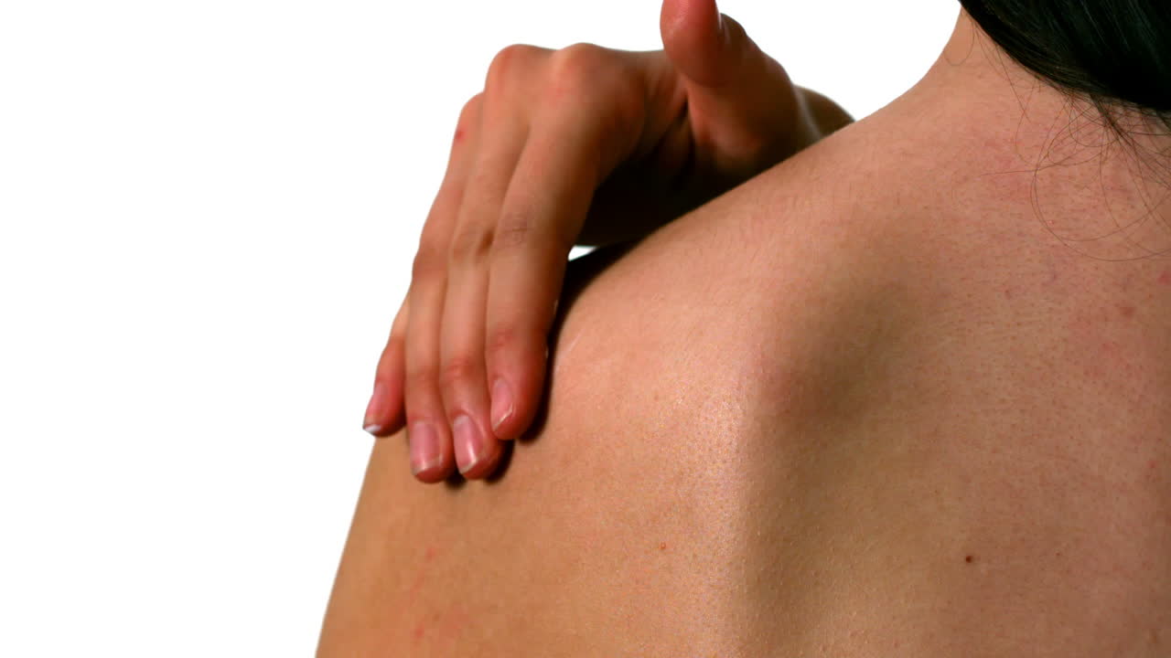 mujer frotando crema hidratante en su hombro