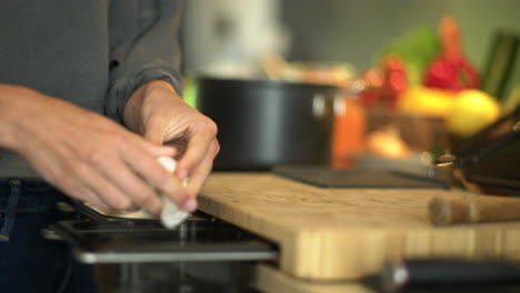 close up of female hands peeling a garlic bulb