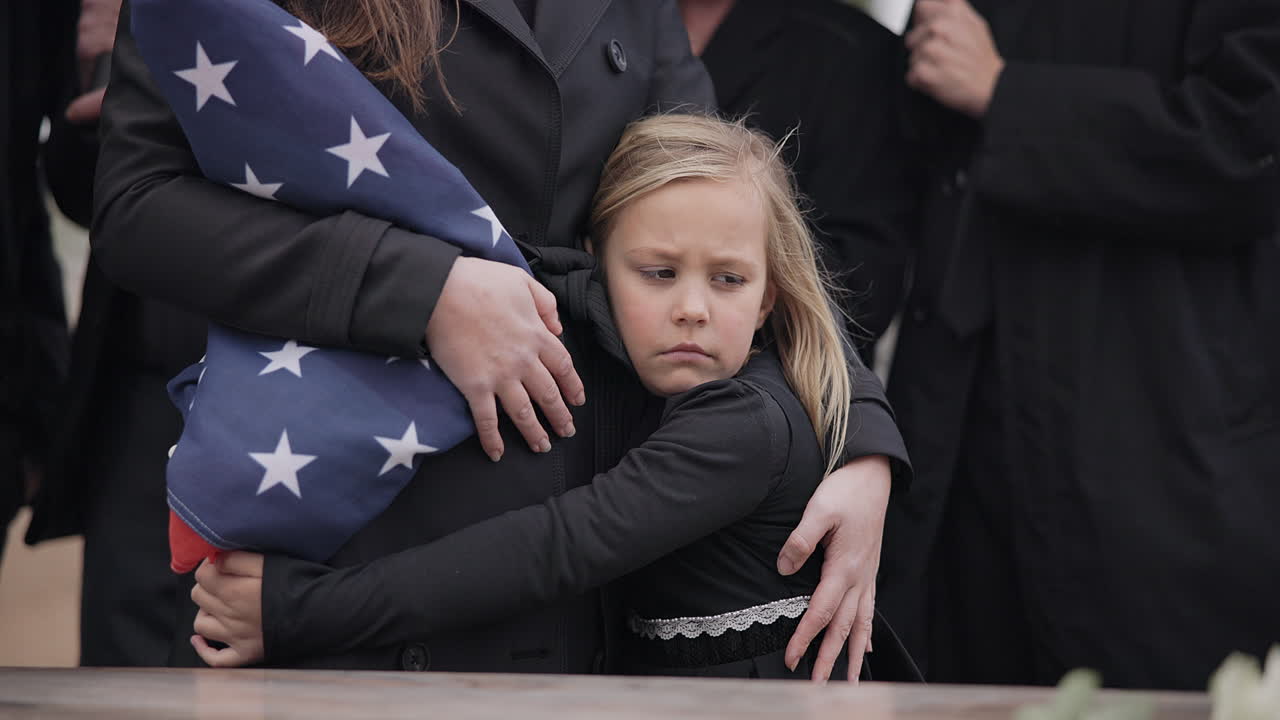 Funerale di veterano USA, ragazza e famiglia triste con abbraccio