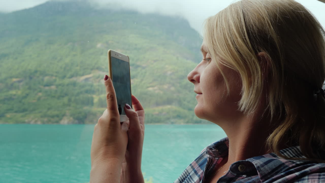 una mujer viaja en autobús en noruega mira por la ventana los hermosos fiordos