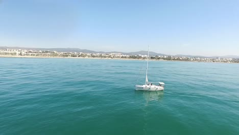 barco de vela con un pueblo mediterráneo