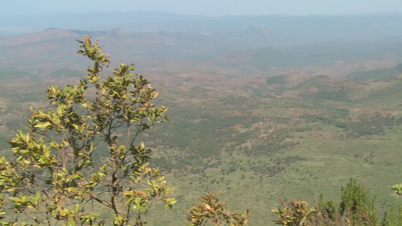 케냐 북부의 광활한 협곡 가장자리에 서 있는 마사이족 전사에게 가로질러 이동합니다.