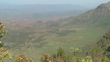 Pan-across-to-a-Masai-warrior-standing-at-the-edge-of-a-vast-canyon-in-Northern-Kenya