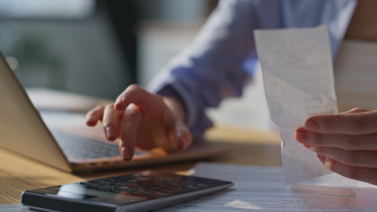 Closeup woman hands calculating receipts on desk home office. Accountant working
