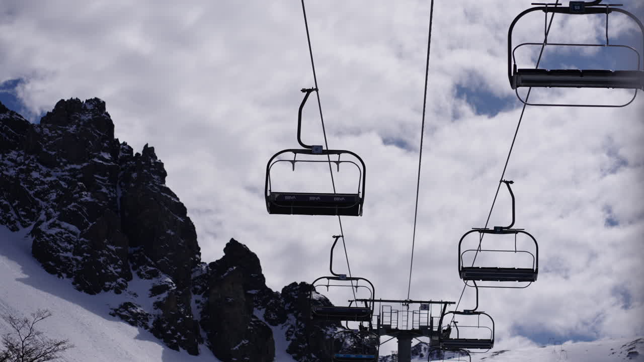 Ski lifting chairs on snowy mountains, static ski center, activity for holidays, cloudy sky, bokeh shot, copy space