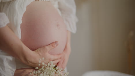pregnant woman stroking belly close-up