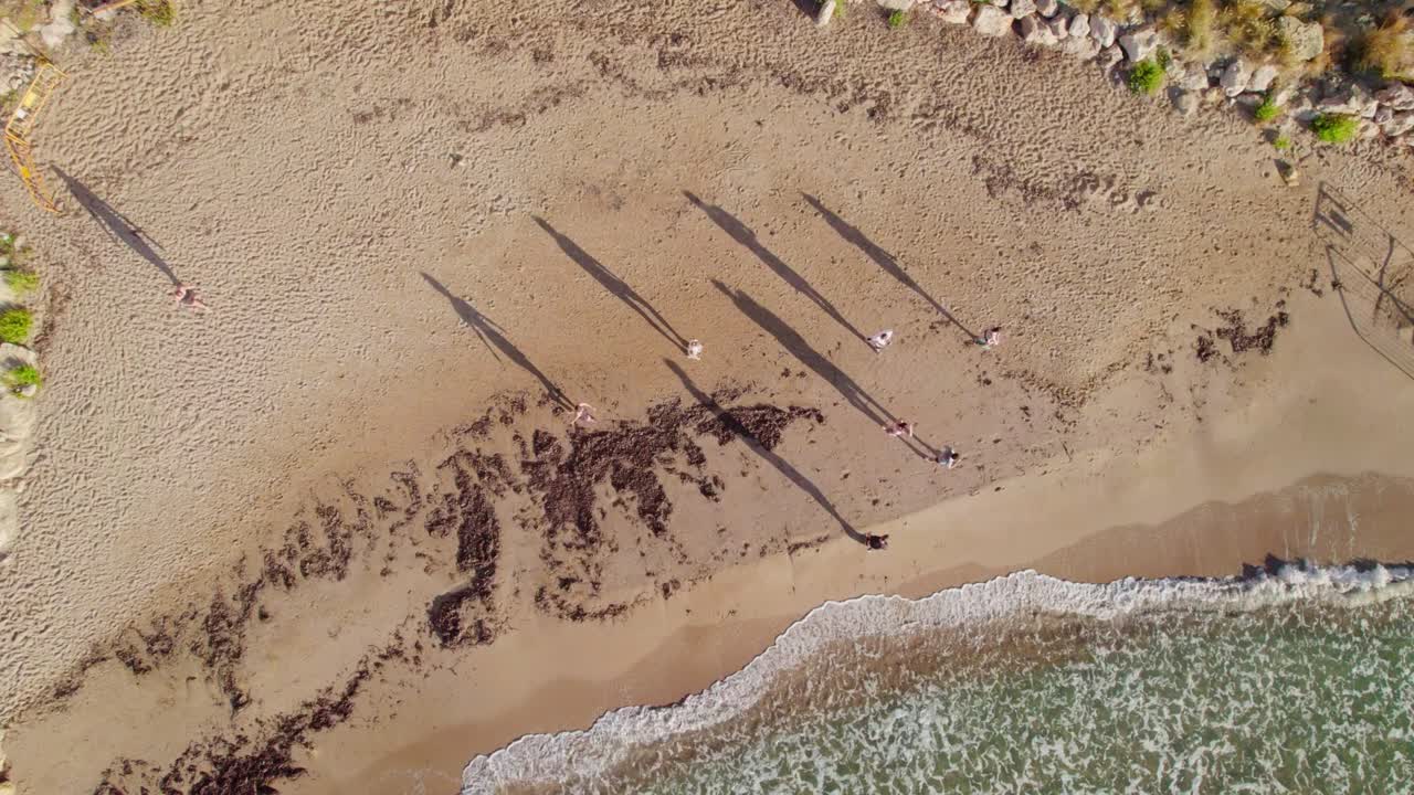 Top View Of People Walking On The Sandy Shores In Summertime. Aerial Tracking Shot