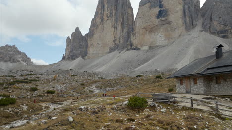 aerial dolly back past rifugio mountain hut with views of tre cime di lavaredo