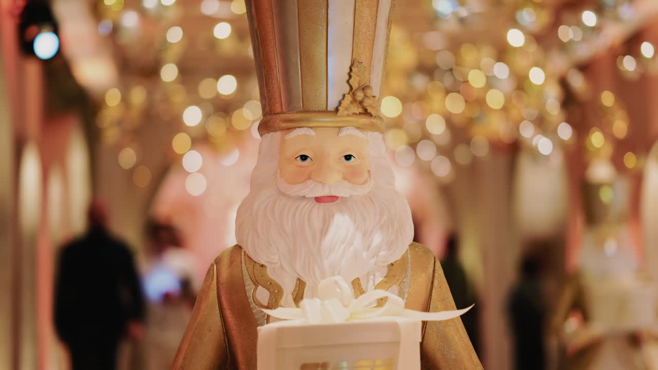 Close up of a Santa Claus figure inside a festive Christmas installation with warm lights and ornaments