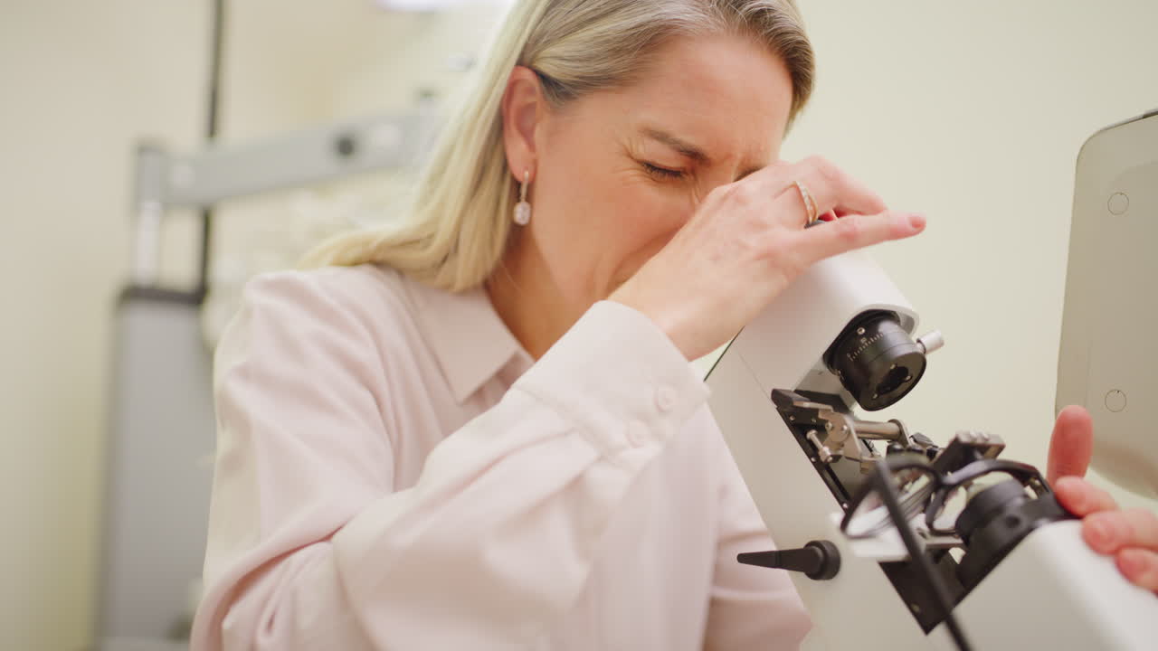 현미경 을 사용 하여 검사 하는 안경학자