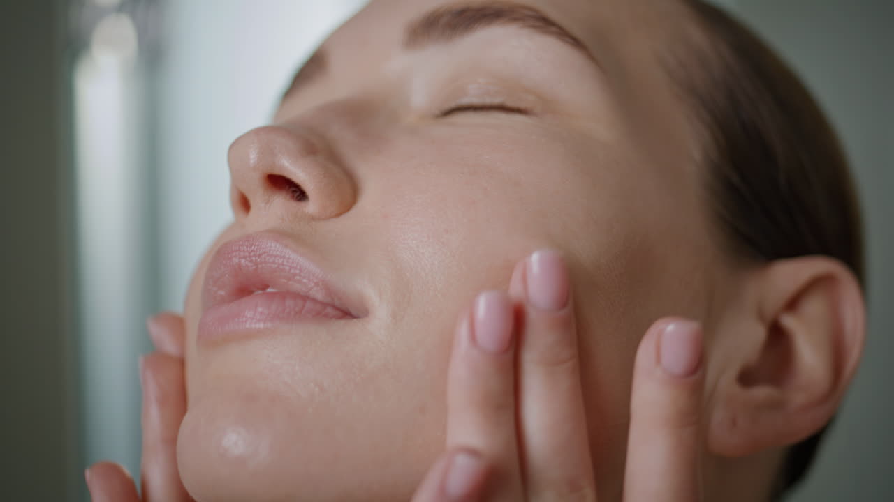 Closeup woman applying cream massaging face skin in morning. Natural beauty