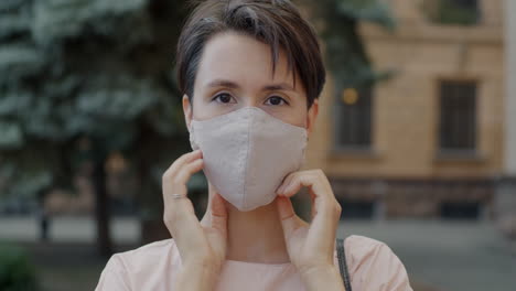 mujer ajustando la máscara facial al aire libre