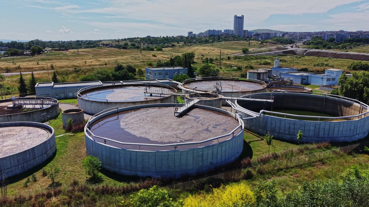Estação de tratamento de água com grandes tanques circulares em uma área rural