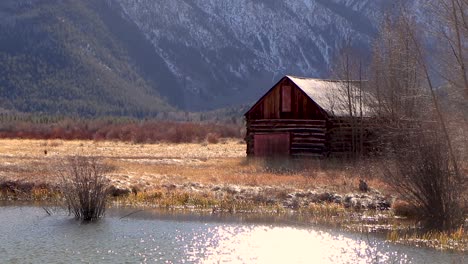 video of a small wooden cabin near a huge snowy mountain range