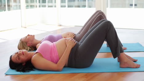 Pregnant-women-doing-yoga-in-fitness-studio