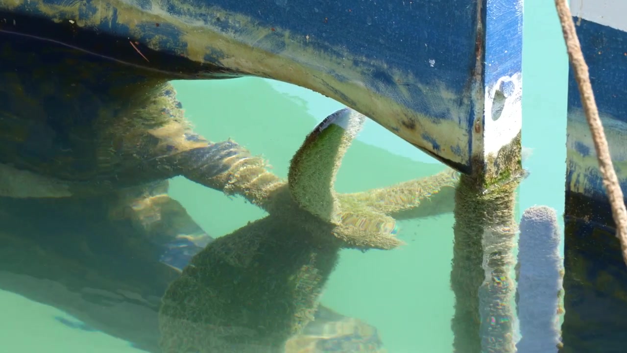 Close-up of a boat propeller submerged in clear turquoise Mediterranean water at Cassis harbor.