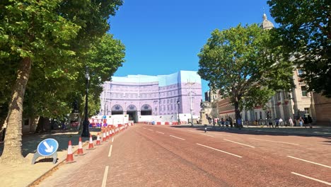 cyclist rides towards marble arch on sunny day