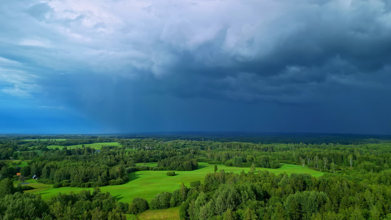 라트비아의 푸른 숲 평야 위에서 흐르는 폭풍우 구름, 공중 사진