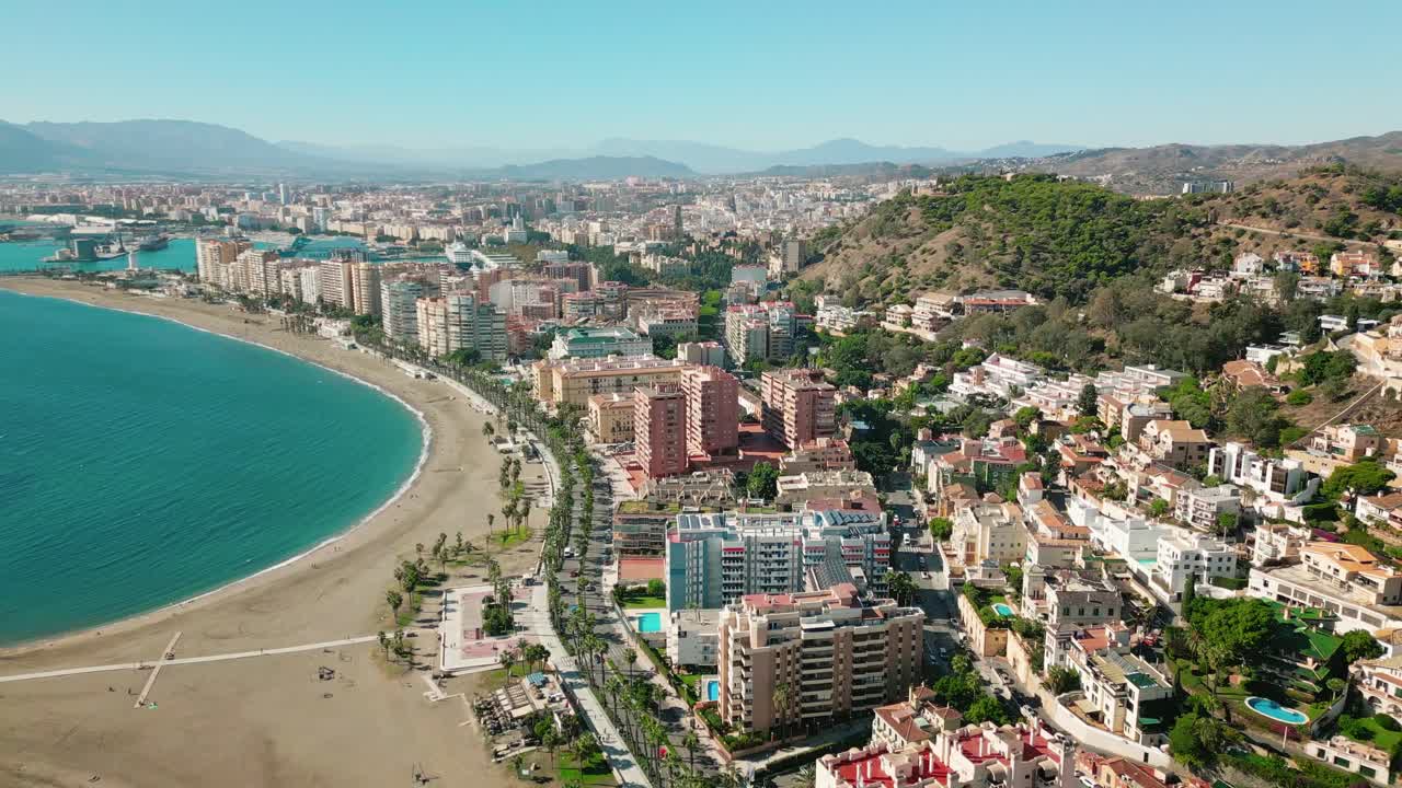 Beautiful Aerial view of Malagueta beach in Málaga coastline, Andalusia, Spain, calm blue Mediterranean waters, coastal city skyline under bright summer light