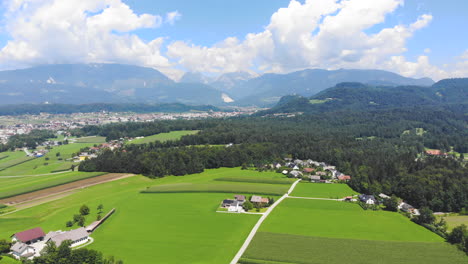 Picturesque-high-aerial-drone-shot-over-grass-meadow-approaching-mountains