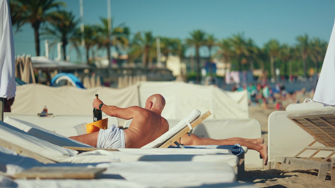 Vacationers sunbathing on comfortable beach loungers near the shoreline, enjoying warm weather and a peaceful seaside resort atmosphere in Antibes, France