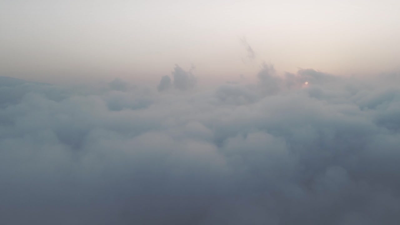 Aerial drone shot of beautiful white clouds passing by during sunset over the sky of Golan Heights, Israel