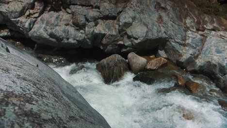 Schäumendes-Wasser,-Das-In-Zeitlupe-Durch-Große-Felsen-Auf-Dem-Fluss-Fließt