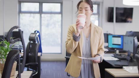 biracial businesswoman drinking coffee in office, slow motion