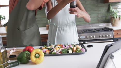 diverse couple prepares a meal in a home kitchen