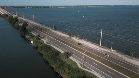 tráfico ligero en la carretera costera con agua hermosa - toma de seguimiento de drones aéreos