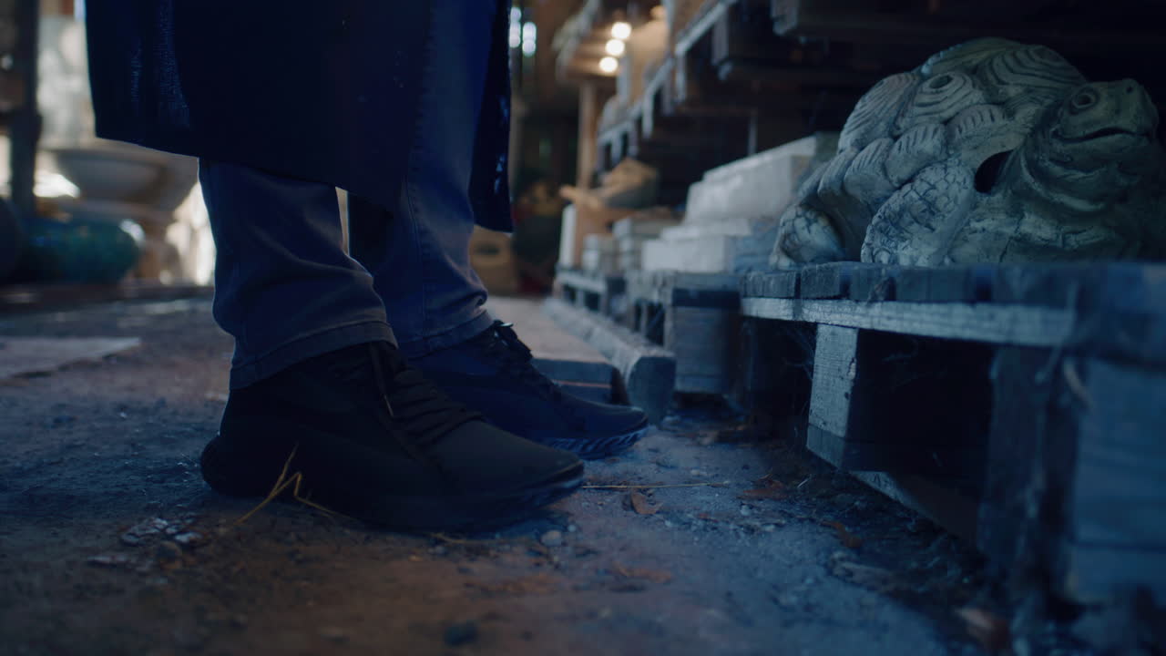 Person standing in a workshop looking at art