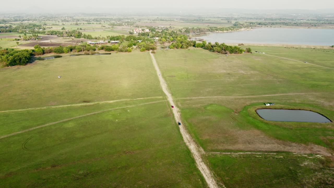 Aerial view shot of Landscape at the end of Pa Sak Jolasid Dam with green grass and water