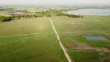 Aerial-view-shot-of-Landscape-at-the-end-of-Pa-Sak-Jolasid-Dam-with-green-grass-and-water