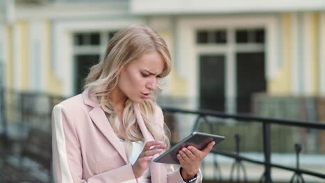 closeup woman getting bad news on touchpad. female working on tablet at street